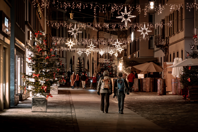 Chur im Advent (© Flavio Schlegel) Advent in Chur, Personen laufen durch Altstadt, Beleuchtung zwischen den Häusern